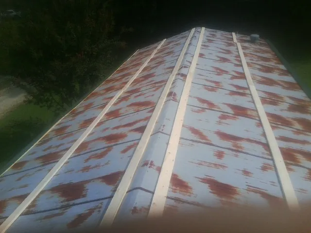 Rusted metal roof panels with new wood purlins before replacement — Storm Damage Roof Repair in Wynnewood by Roofing Brothers